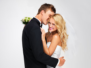 Image showing Wedding, couple and marriage with a bride and groom as a couple in studio against a white background. Dress, suit and flowers with a man and woman getting married at a celebration event or ceremony