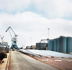 Image showing Logistics, shipping and supply chain on a harbor with a factory, warehouse or plant and crane in the background. Manufacturing, cargo and freight for delivery in the export and import industry