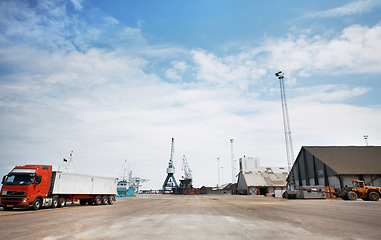 Image showing Logistics, supply chain or shipping with a factory, warehouse or plant in the background of a harbor and a truck and crane on the dock. Delivery, cargo and transport in the export and import industry