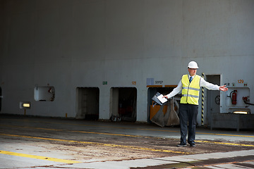 Image showing Logistics worker, manager or engineer, working in a shipping yard or cargo dock. Port employee, giving direction to load container for safety, storage or export. Industrial management and planning.