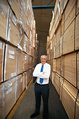 Image showing Portrait of shipping, logistics and delivery manager in a supply chain warehouse with a smile and arms crossed. Mature man employer in a cargo and stock container factory in the export industry