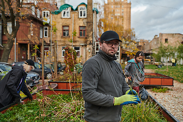 Image showing A modern family parents and children, is working together to beautify their front yard with flowers in preparation for the upcoming holiday season.