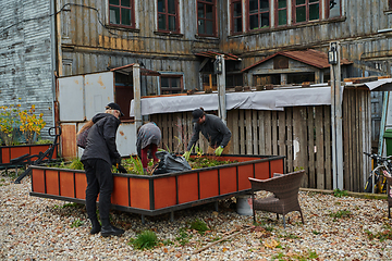 Image showing A modern family parents and children, is working together to beautify their front yard with flowers in preparation for the upcoming holiday season.