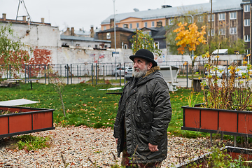 Image showing In the historic city of Riga, a bearded elderly man passionately explains the traditional symbolism of Halloween, connecting generations through cultural heritage and folklore.