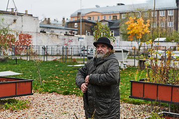 Image showing In the historic city of Riga, a bearded elderly man passionately explains the traditional symbolism of Halloween, connecting generations through cultural heritage and folklore.