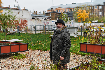 Image showing In the historic city of Riga, a bearded elderly man passionately explains the traditional symbolism of Halloween, connecting generations through cultural heritage and folklore.