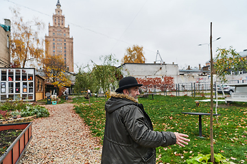 Image showing In the historic city of Riga, a bearded elderly man passionately explains the traditional symbolism of Halloween, connecting generations through cultural heritage and folklore.