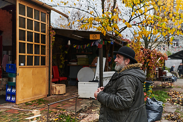 Image showing In the historic city of Riga, a bearded elderly man passionately explains the traditional symbolism of Halloween, connecting generations through cultural heritage and folklore.