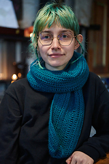 Image showing A modern and intriguing girl with striking blue hair enjoys a night out in a cafe transformed into a passionate Halloween-style setting, exuding a captivating and witchy ambiance