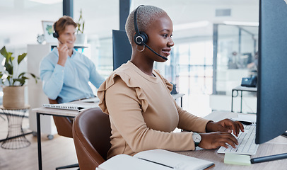 Image showing Black call center, telemarketing, and customer service consultant typing on computer for database information a busy office. Contact us and crm agent offering support, help and service with a smile