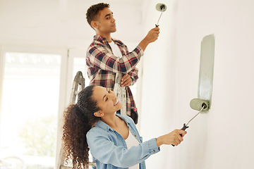 Image showing Painting, love and renovation with a couple doing DIY in a room for improvement and remodel of their home. Young man and woman working with green paint on a wall to renovate their domestic house