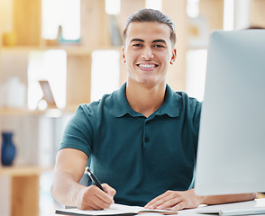 Image showing Planning, vision and motivation with business man writing notes in a book while working on a computer in a corporate office. Inspired employee on mission, researching upskill course, being proactive