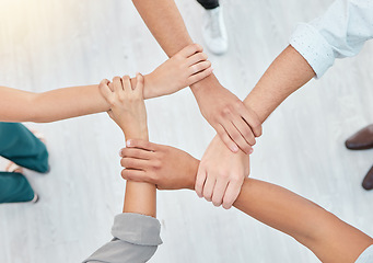 Image showing Hope, partnership and support group holding each other at community therapy session. Top view of people doing motivation, love and trust exercise while building a connection at mental health clinic.