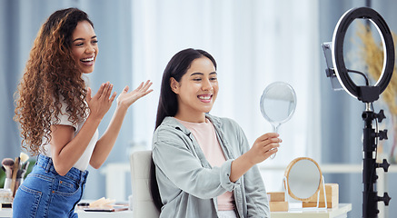 Image showing Woman recording a makeup tutorial with a client for her beauty blog or vlog using her phone at home. African American female influencer live streaming her cosmetic skills for social media