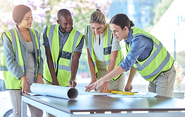 Image showing Industrial engineer team planning with blueprint paperwork in a meeting in an office or boardroom. Architect group of people collaborate on a building project working together on the design