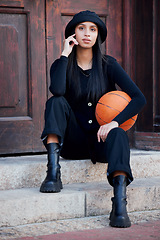 Image showing Fashion model, influencer and young woman with basketball posing on steps in urban city. Portrait of trendy, stylish and cool person with funky attitude, grunge personality and modern black clothes