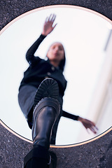 Image showing Mirror, reflection and fashion shoes of a woman standing on a blur vision of herself in the street outdoors. Female person on glass with shoe in reflect for self awareness in edgy, cool and style.