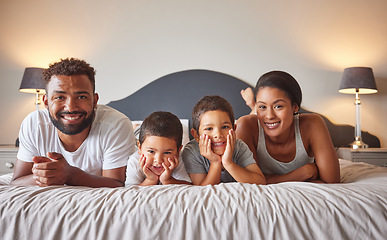 Image showing Portrait of parents and kids lying on bed in the morning with a smile. Playful, fun, mom and dad playing indoors showing growth, child development, happiness and childhood innocence from little boys