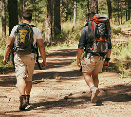 Image showing Backpacker friends explore nature while hiking in a forest together, being active and bonding outdoors. Active men on a path in the woods, enjoying a physical challenge while on trekking adventure