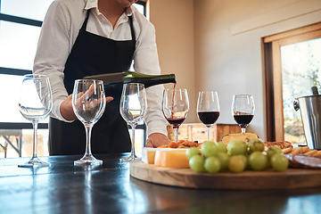 Image showing Hospitality, industry, and luxury wine service with waiter pouring in glasses, prepare for wine tasting at restaurant. Professional sommelier setting up for fine dining experience with alcohol