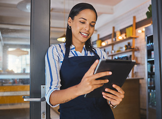 Image showing Startup, entrepreneur and female cafe owner working on a digital tablet to plan a budget. Proud, positive and successful leader checking inventory. Small business owner with door open to customers