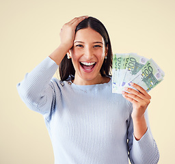 Image showing Woman celebrating success, winning money or lottery victory, holding cash or banknotes in hand. Portrait of excited, happy and proud winner screaming and laughing, with yellow copyspace background.