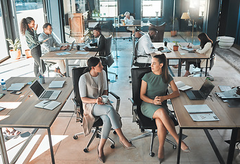 Image showing Open office space policy business people having in formal discussion at their desk in a busy, collaboration corporate workplace. Professional employee or staff talking while working on company plan