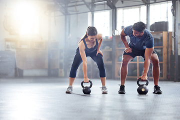 Image showing Fitness couple doing a kettlebell workout, exercise or warmup training in a gym. Fit sports people, woman and man with a strong grip, exercising using equipment to build muscles and forearm strength.