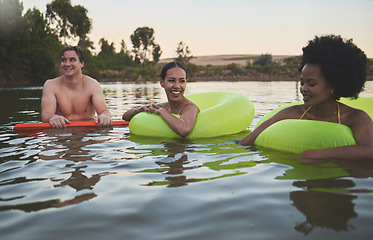 Image showing Fun group of diverse friends relaxing in lake water, enjoying nature and bonding on a getaway vacation in the countryside together. Happy men and women laughing, smile and looking relaxed on holiday