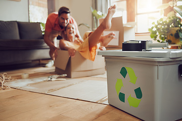 Image showing Fun couple moving into new house, playing with boxes and being playful after relocation to apartment together. Carefree man and woman recycling at home, living sustainable and reducing waste