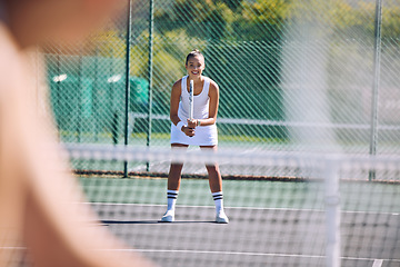 Image showing Female tennis player with racket equipment or gear preparing for match at outdoor sport activity from opponent POV. Young athletic or sportswoman standing ready and looking competitive in sportswear