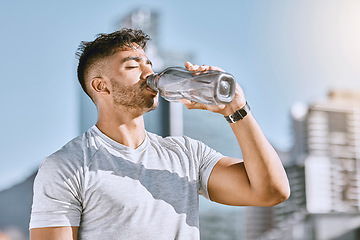 Image showing Fitness, healthy thirsty man drinking water while he is exercising outside in sportswear. Runner, cardio workout and active lifestyle for strong athletic body or mental discipline.