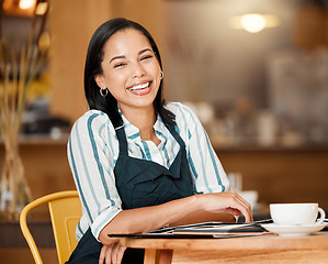 Image showing Coffee shop owner looking proud and happy while doing paperwork and having coffee break. Young business woman checking stock, orders and inventory, enjoying her career. Positive lady managing a cafe