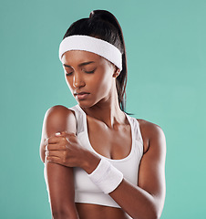 Image showing Tennis player with sports injury, hurt or pain in her arm after practice against green studio background. Professional female athlete suffering muscle strain, accident and inflammation on her body