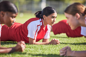 Image showing Women soccer players in a team doing the plank fitness exercise in training together on a practice sports field. Healthy female group of young athletes doing a core strength workout using teamwork