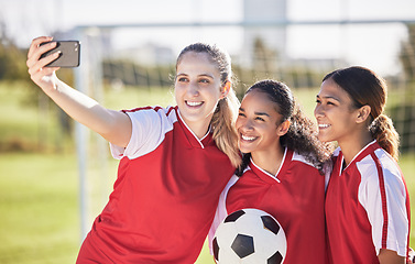 Image showing Selfie, soccer and sports team smiling and feeling happy while posing for a social media picture. Diverse and young girls standing together on a football field. Friends and teammates enjoying a match