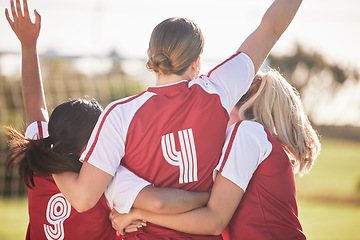 Image showing Female football team celebrating winning, goal or teamwork effort at a game, tournament or during practice on a field outdoors. Behind of women with arms raised in celebration, victory and joy