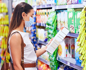 Image showing Customer, shopper and consumer reading label for nutritional ingredients on products, stock and groceries while shopping in supermarket store in covid pandemic. Woman deciding choice to buying food