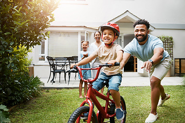 Image showing Learning, bicycle and proud dad teaching his young son to ride while wearing a helmet for safety in their family home garden. Active father helping and supporting his child while cycling outside
