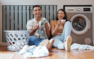 Image showing Happy, relaxed and responsible couple doing laundry, household chores or cleaning together on the weekend at home. Young millennial boyfriend and girlfriend enjoying their new modern washing machine