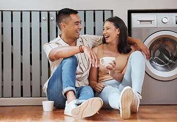 Image showing Happy, carefree and romantic couple bonding, laughing and having fun while sitting on the floor. Loving cheerful husband and wife having a cup of coffee, talking and relaxing in the kitchen at home