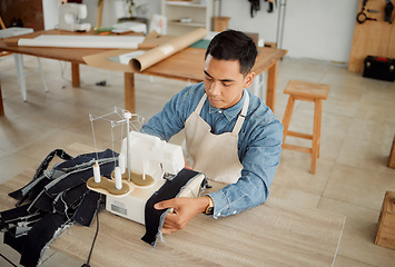 Image showing Creative fashion designer or seamstress tailor working on sewing trendy and stylish clothing garment in design studio workshop. Young male dressmaker working on fabric material with machine stitch