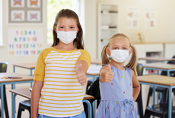 Image showing School kids, thumbs up and healthy students wearing masks in a classroom protecting against covid. Portrait of cute, young and friendly girls in a safe learning and educational environment together