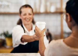 Image showing Customer buying a hot cup of coffee from a happy barista giving good and friendly service at a local cafe shop. Smiling startup entrepreneur and owner handing a drink in a tea store