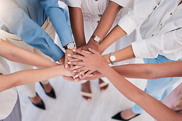 Image showing United, successful or ambitious businesspeople hands stacked together in a work office. Business professionals having fun standing with their hands piled for motivation during a meeting from above