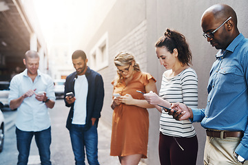 Image showing Business people reading text on phone, checking notifications and typing messages online during a break at work. Group of diverse colleagues scrolling on the internet, browsing app and networking