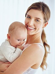 Image showing Mother bonding with baby boy, smiling and enjoying family time in a room at home. Portrait of a happy, loving and caring single parent holding or carrying an adorable, cute and little newborn child