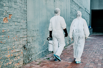 Image showing Healthcare workers wearing protective hazmat suits to help prevent the spread of a toxic infection or covid pandemic. First responders cleaning a building for better hygiene and safety