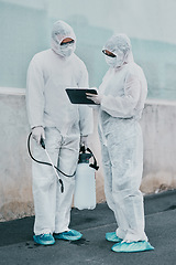 Image showing Healthcare workers cleaning outside a building using a list to follow instructions on biohazard safety during covid. Medical researchers wearing hazmat suits sanitizing outdoor to prevent infections