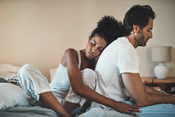 Image showing Woman tries to embrace her husband with affection after their fight at home. Unhappy interracial couple with marriage problems forgive each other. Empathy and guilty feelings after the affair.